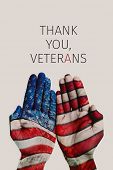 closeup of the hands of a man patterned with the flag of the United States and the text thank you ve