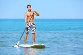picture of fitness  - Stand up paddle board man paddleboarding on Hawaii standing happy on paddleboard on blue water - JPG 