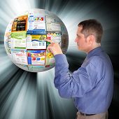 pic of internet  - A business man is pointing to an abstract internet ball with websites on it - JPG 