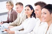 stock photo of business people  - Five business people sitting in a row and writing notes on a business training - JPG 