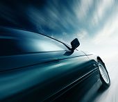 picture of tilting  - Blurred car and blue sky with clouds - JPG 