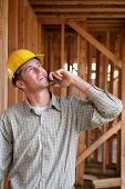 pic of construction worker  - A handsome construction worker on the job and on the phone - JPG 