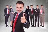 picture of leadership  - young business man leader of a successful team making the thumbs up ok gesture - JPG 