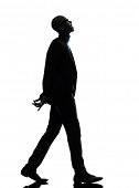 image of man  - one african  black man walking looking up smiling  in silhouette studio on white background - JPG 