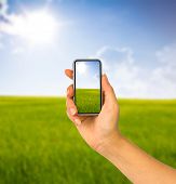 foto of country  - Cell phone in hand and country view of sunny day - JPG 