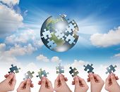 stock photo of globe  - Business concept with a hand building puzzle globe - JPG 