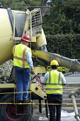 pic of construction worker  - two construction workers fixing the road wearing yellow and red hard hats and yellow safety wear - JPG 