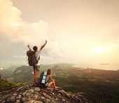 picture of valley  - Two hikers with backpacks standing on top of a mountain with great valley view - JPG 