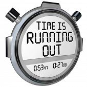 stock photo of timer  - A stopwatch or timer with the words Time is Running Out to warn you that the clock is ticking and the deadline or finish point is near and you should hurry or speed up to complete the game or job - JPG 