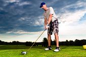 image of golf  - Young golf player on course doing golf swing - JPG 