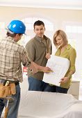 foto of home  - Smiling couple discussing ground plan of new home with builder - JPG 