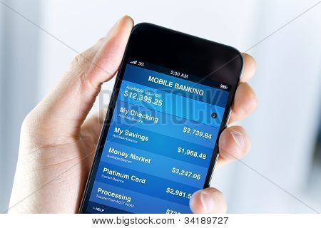 Picture or Photo of A man holding smartphone with mobile banking application on a screen. Closeup shot.