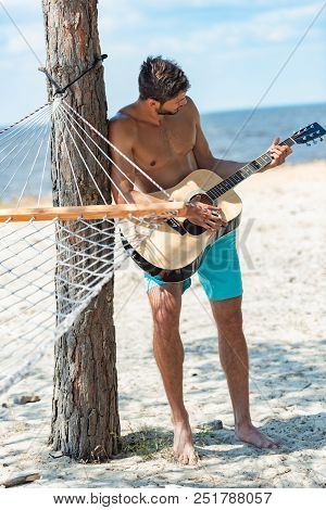 Poster: Young Shirtless Man Playing Acoustic