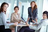 picture of meeting  - Image of four successful businesswomen looking at camera at meeting - JPG 
