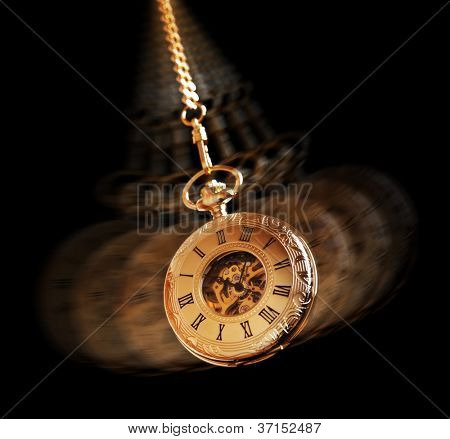 Picture or Photo of Hypnotism concept, gold pocket watch swinging used in hypnosis treatment