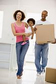 image of home  - Family moving into new home smiling husband carrying boxes - JPG 
