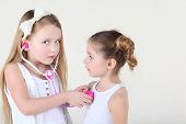 picture of heartbeat  - Little girl in white dress listens heartbeat of another girl by toy phonendoscope and looks at camera - JPG 