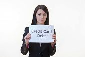 picture of debt  - woman holding up a piece of paper with the words credit card debt written on it and tearing the sheet of paper in half - JPG 