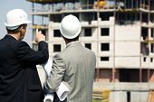 foto of construction  - Photo of successful architect pointing to the building with foreman near by - JPG 