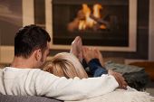 pic of home  - Couple sitting on sofa at home in front of fireplace rear view - JPG 