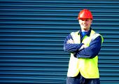 stock photo of construction worker  - construction worker standing with arms folded - JPG 
