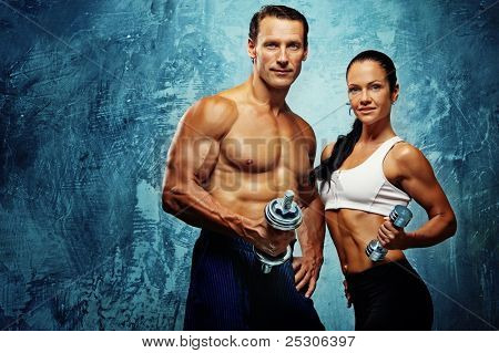 Picture or Photo of Athletic man and woman with a dumbells.
