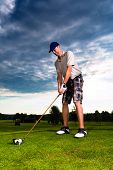 picture of golf  - Young golf player on course doing golf swing - JPG 