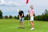 pic of golf  - Young sportive couple playing golf on a golf course - JPG 