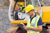 picture of construction  - construction manager writing report at construction site - JPG 