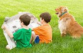 stock photo of newspaper  - Two Boys Reading the Newspaper with the Dog - JPG 