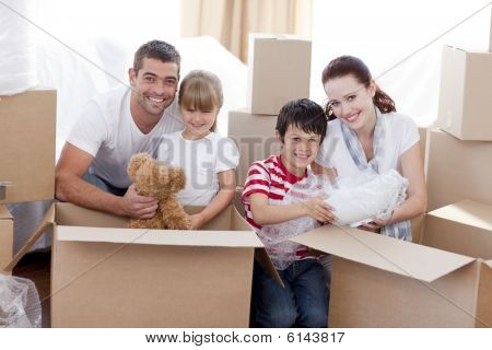 Picture or Photo of Happy young family Moving Home With Boxes Around