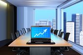 foto of meeting  - meeting room in front focus placed on graph shiwing progress on laptop screen - JPG 