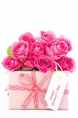 picture of nature  - Bouquet of beautiful pink roses next to a pink gift with a happy mothers day card on white background close up - JPG 