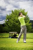 stock photo of golf  - Male golf player teeing off golf ball from tee box - JPG 