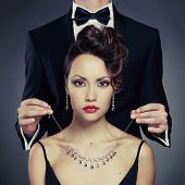 stock photo of grace  - Elegant man on a beautiful woman wears a necklace - JPG 