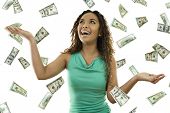 picture of money  - Stock image of woman standing with open arms amidst falling money - JPG 