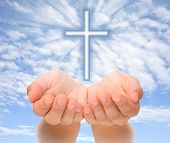 pic of beams  - Hands holding Christian cross with light beams over sky - JPG 