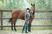 foto of horse  - Woman jockey is riding the horse outdoor - JPG 