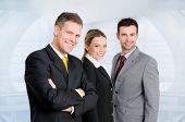 stock photo of business people  - Three happy business colleagues standing together and looking at camera in their modern office - JPG 