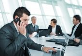 picture of meeting  - Business man speaking on the phone during meeting - JPG 