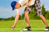 foto of golf  - Young golf player on course putting - JPG 