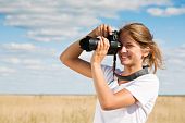 stock photo of blue sky  - Young girl taking photo against blue sky - JPG 