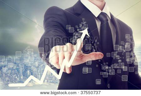 Picture or Photo of Businessman Touching a Graph Indicating Growth on City Background