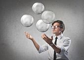 picture of future  - Businessman juggling with some air bubbles - JPG 