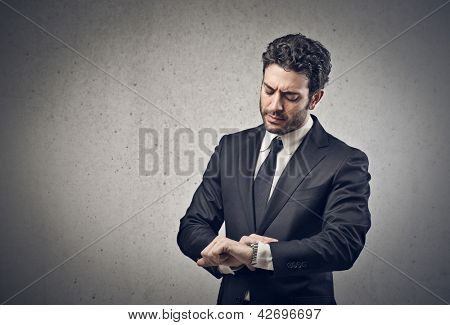 Picture or Photo of Young businessman looking his watch