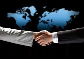 stock photo of handshake  - business handshake against black background with map image - JPG 