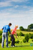 foto of golf  - Young female golf player at Driving Range with a Golf Pro - JPG 