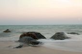 stock photo of blue sky  - Stormy waves hitting rock on a tropical beach - JPG 