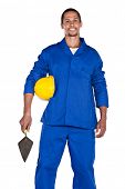 foto of construction worker  - mixed race construction worker with yellow hard hat and trowel - JPG 