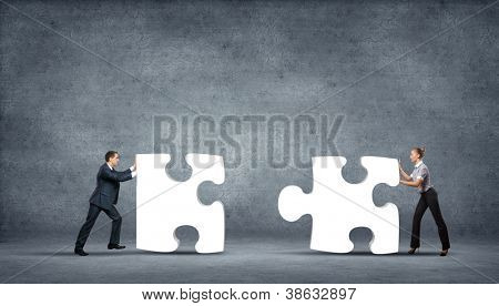 Picture or Photo of Team of business people collaborate holding up jigsaw puzzle pieces as a solution to a problem
